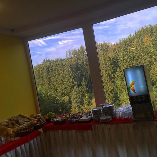 un tavolo con vista su una grande finestra con tavolo sidro di Hotelový resort Šikland a Zvole