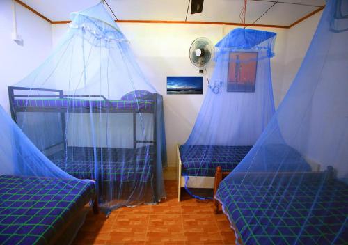 two bunk beds in a room with blue nets at Yuthika Resort in Negombo