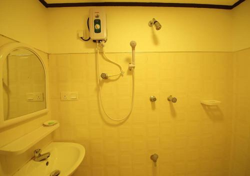 a bathroom with a shower and a sink at Yuthika Resort in Negombo