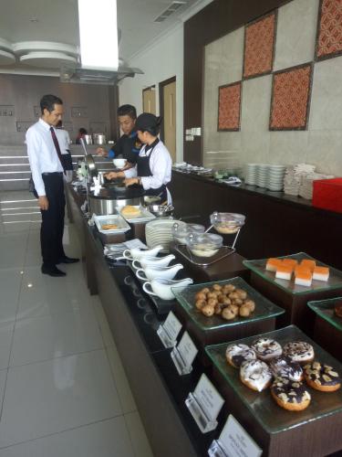 a group of people in a kitchen preparing food at Hotel Santika Luwuk - Sulawesi Tengah in Luwuk