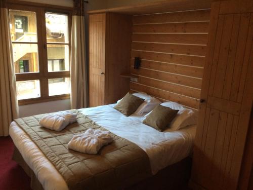 a bedroom with a large bed with two pillows on it at Les Arcs 1950 - appartement 6 pers. in Arc 1950