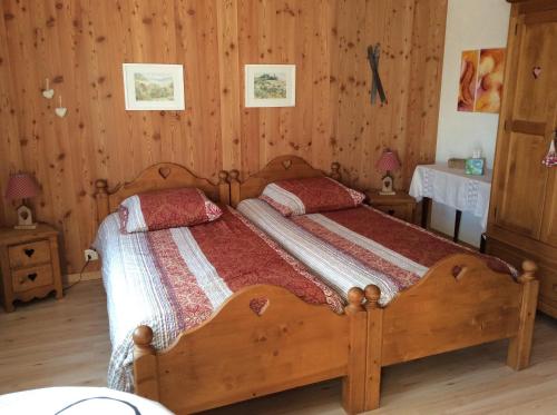 a bedroom with a wooden bed with two pillows at La Bergerie - chalet Alice in Choex