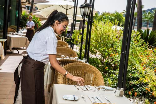 a woman standing at a table in front of a table set up at Mon Port Hotel & Spa in Port d’Andratx