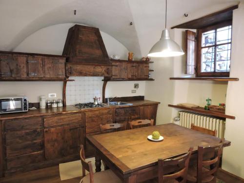 a kitchen with wooden cabinets and a wooden table at Baita del Plan in Pragelato