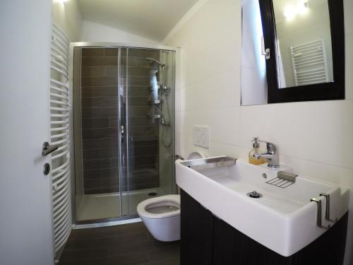 een badkamer met een douche, een wastafel en een toilet bij apartman Adriana 3 - kat in Poreč