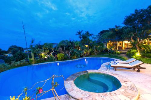 an outdoor swimming pool with a bench next to it at Casa Jimbaran Villa in Jimbaran