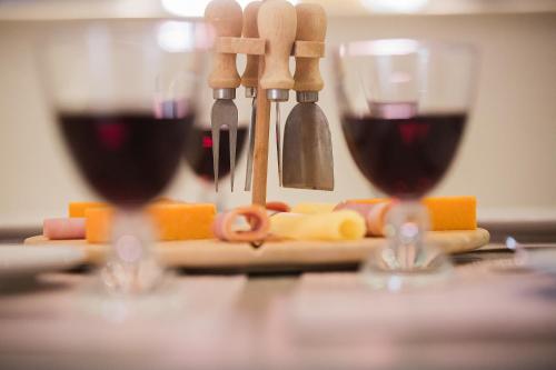two glasses of red wine sitting on a table at Penelope Corfu Suite in Corfu Town