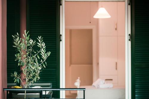 ein grünes Haus mit einem Tisch und einem Spiegel in der Unterkunft Penelope Corfu Suite in Korfu-Stadt
