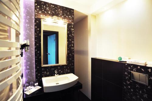 a bathroom with a sink and a mirror at Hotel 3 Trio in Białystok