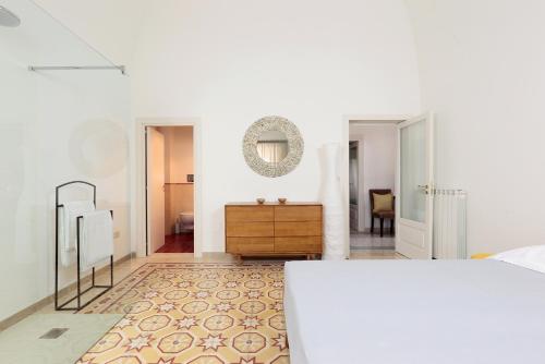 biała sypialnia z komodą i lustrem w obiekcie Villa Aurelia - guesthouse Le Case di Aurelia w mieście Castellana Grotte