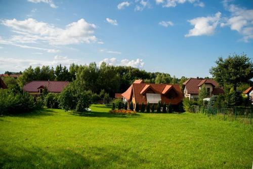 a large green yard with houses in a field at ekoLOKUM - kameralnie, blisko centrum in Ostróda