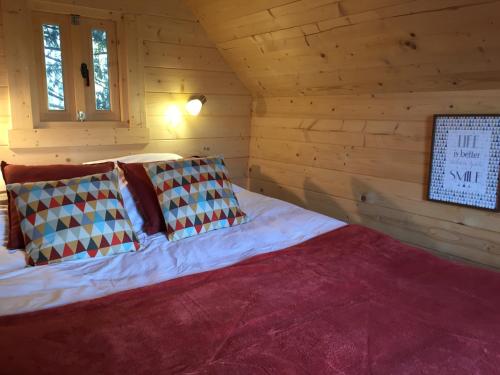 um quarto com uma cama num chalé de madeira em Cabane Aligoté em Saint-Albain