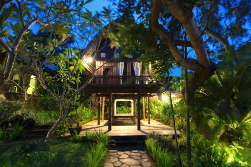 a tree house in the middle of a garden at night at Casa Jimbaran Villa in Jimbaran