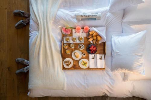 a tray of food on top of a bed at Hostellerie du Pas de l'Ours "Relais et Châteaux" in Crans-Montana