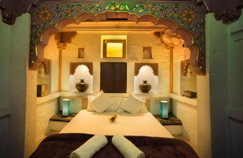 a bedroom with a large bed with two pillows at Jewel Palace Haweli in Jodhpur