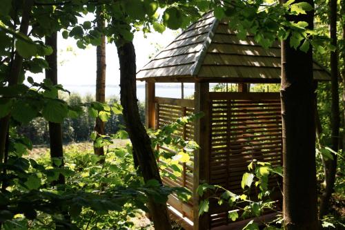 a wooden gazebo in the middle of a forest at Hotel Vejlefjord in Stouby