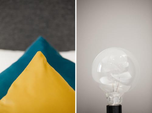 a glass light bulb next to a yellow and blue napkin at Moment Hotels in Malmö