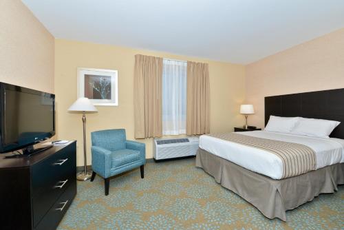 a hotel room with a bed and a flat screen tv at Suburban Studios Quantico in Stafford