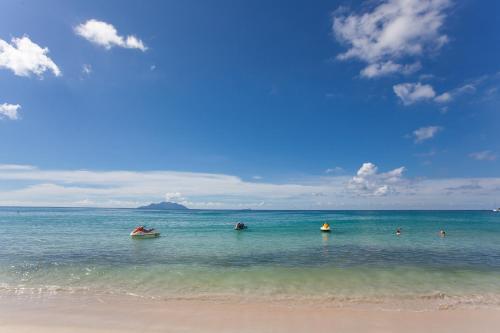 a group of people in the water at the beach at Sables d'Or Luxury Apartments in Beau Vallon