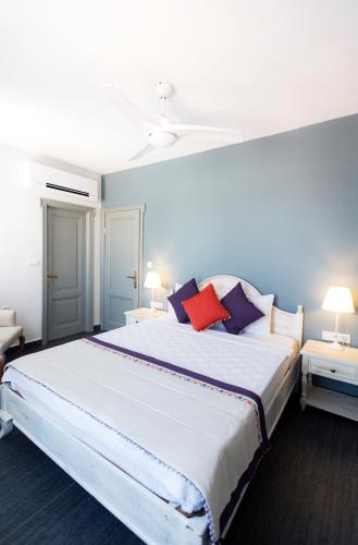 a bedroom with a large white bed with pillows at Kapya Cunda in Ayvalık