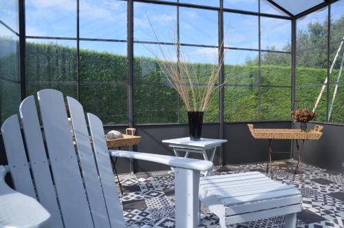 a room with white chairs and a large window at La Petite Aiguebonne in Allex