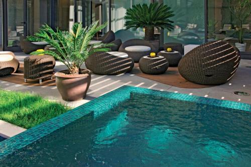 a swimming pool in a building with chairs and plants at Maistra Select All Suite Island Hotel Istra in Rovinj