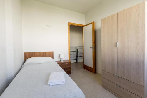 1 dormitorio con 2 camas y armario de madera en Apartamentos Fernando de los Rios, en Granada