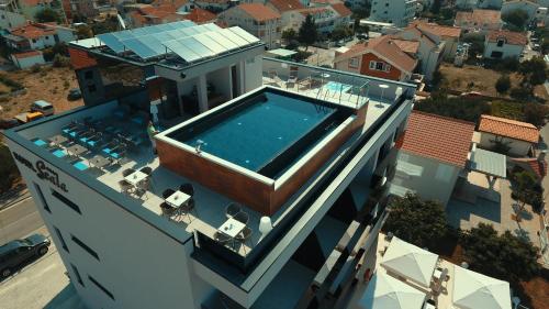 a house with a swimming pool on top of a building at Hotel Scala d'Oro in Vodice