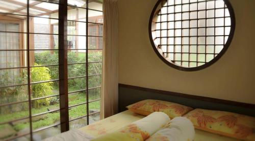 a bedroom with a bed and a large window at Villa Kota Bunga Ade Type Jepang - 0228 in Cibadak