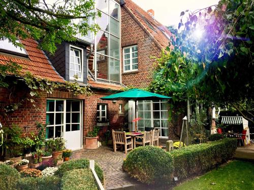 a brick house with a table and an umbrella at Lilis kleines Hotel in Münster