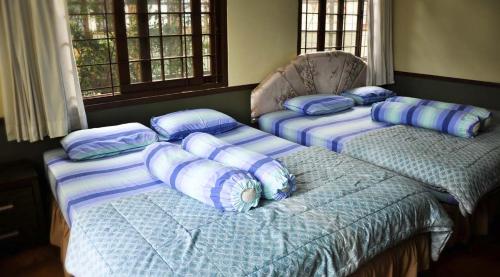 three beds in a room with blue pillows on them at Villa Kota Bunga Ade Type Jepang - 0222 in Cibadak