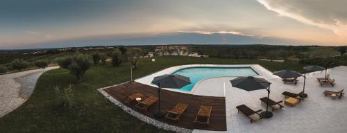 an overhead view of a swimming pool with umbrellas at Wine Residence Cattunar in Brtonigla