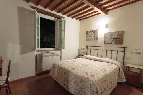 a bedroom with a bed and a window at Hotel Giuly in Torre del Lago Puccini