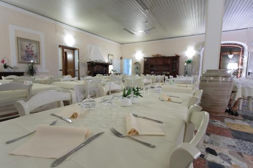 a dining room with white tables and white chairs at Hotel Giuly in Torre del Lago Puccini
