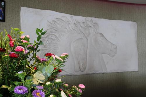 a statue of a horse on a wall with flowers at Best Western Heath Court Hotel in Newmarket