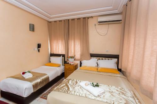 A bed or beds in a room at Hôtel Jawharat El Jadida