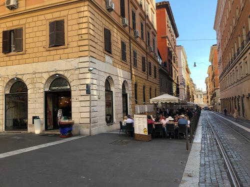 un grupo de personas sentadas en mesas en una calle de la ciudad en Hotel Cherubini, en Roma