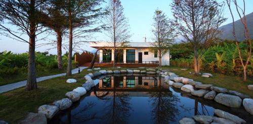 a house with a stone bridge over a pond at 太魯閣研海泊別墅 Taroko Yan Hai Bo Villa in Xincheng