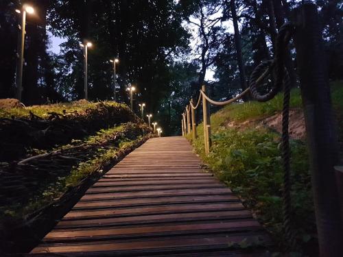 a wooden path at night with street lights at Small resort Pini & SPA in Jūrmala