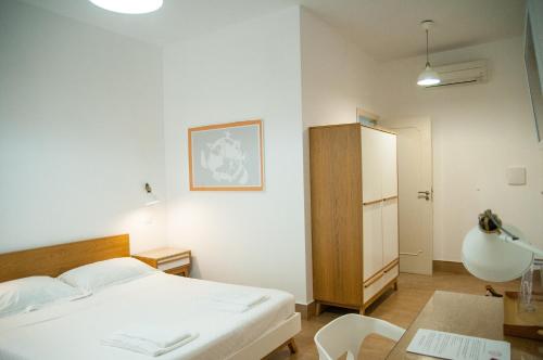 a bedroom with a bed and a table and a chair at Mediterraneo Guesthouse in Giardini Naxos