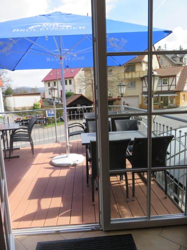 a balcony with a table and an umbrella at Fraenkischer Hof in Zeitlofs