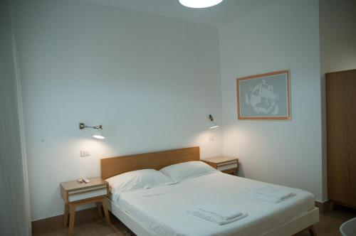 a bedroom with a bed and two night stands at Mediterraneo Guesthouse in Giardini Naxos