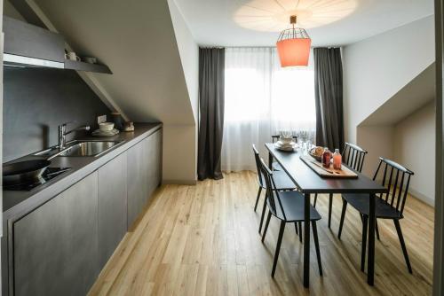 uma cozinha e sala de jantar com uma mesa preta e cadeiras em Bold Hotel Frankfurt Messe em Frankfurt am Main