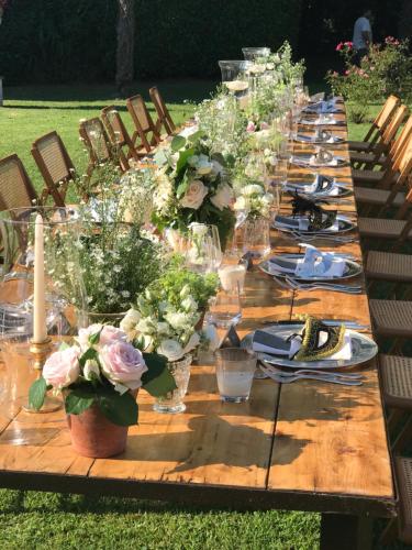 a long wooden table with plates and flowers on it at Hotel Villa Condulmer in Mogliano Veneto