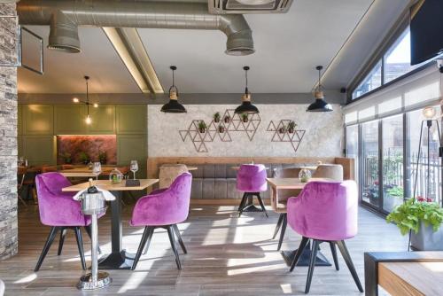 a dining room with purple chairs and tables at Hotel Galija in Pula