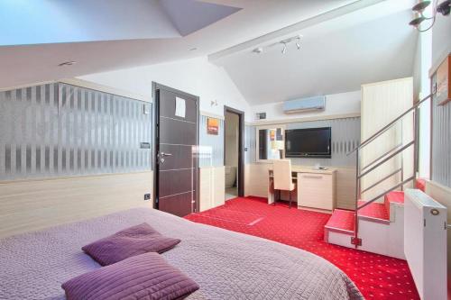 a bedroom with a bed and a desk and a television at Hotel Galija in Pula