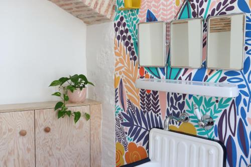 a bathroom with a colorful patterned wall at Le Petit Rivage in La Charité-sur-Loire