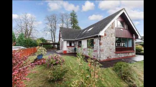 a small house with a garden in front of it at Forty Winks Loch Lomond in Balloch