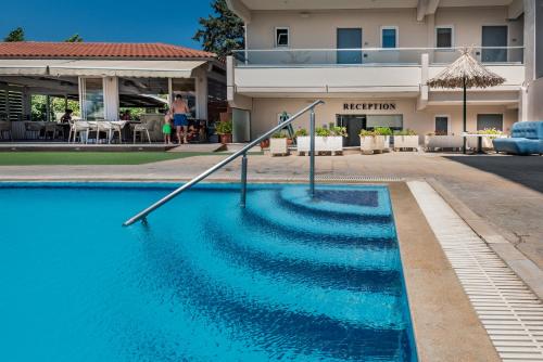 a swimming pool in front of a hotel at Sunday Hotel in Ialyssos