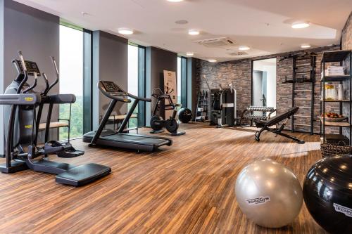 a gym with treadmills ellipticals and exercise equipment at Airport Plaza Hotel Hamburg in Norderstedt